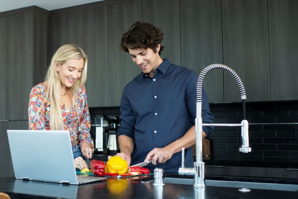 Couple in kitchen using WiFi at home