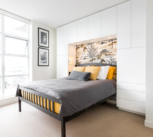 custom storage unit built above and on either side of a queen-sized bed by California Closets Vancouver, British Columbia.