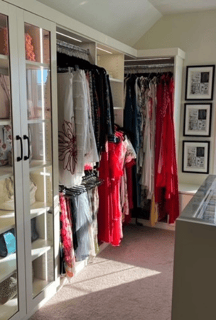 Bedroom closet with hanging space and storage shelving behind glass doors.