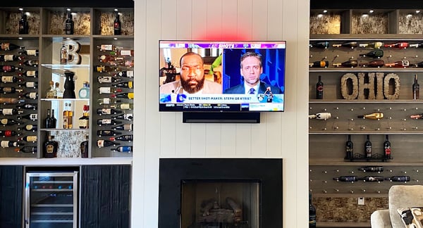 Home entertainment center design with custom shelving and cubbies for wine storage by California Closets Atlanta