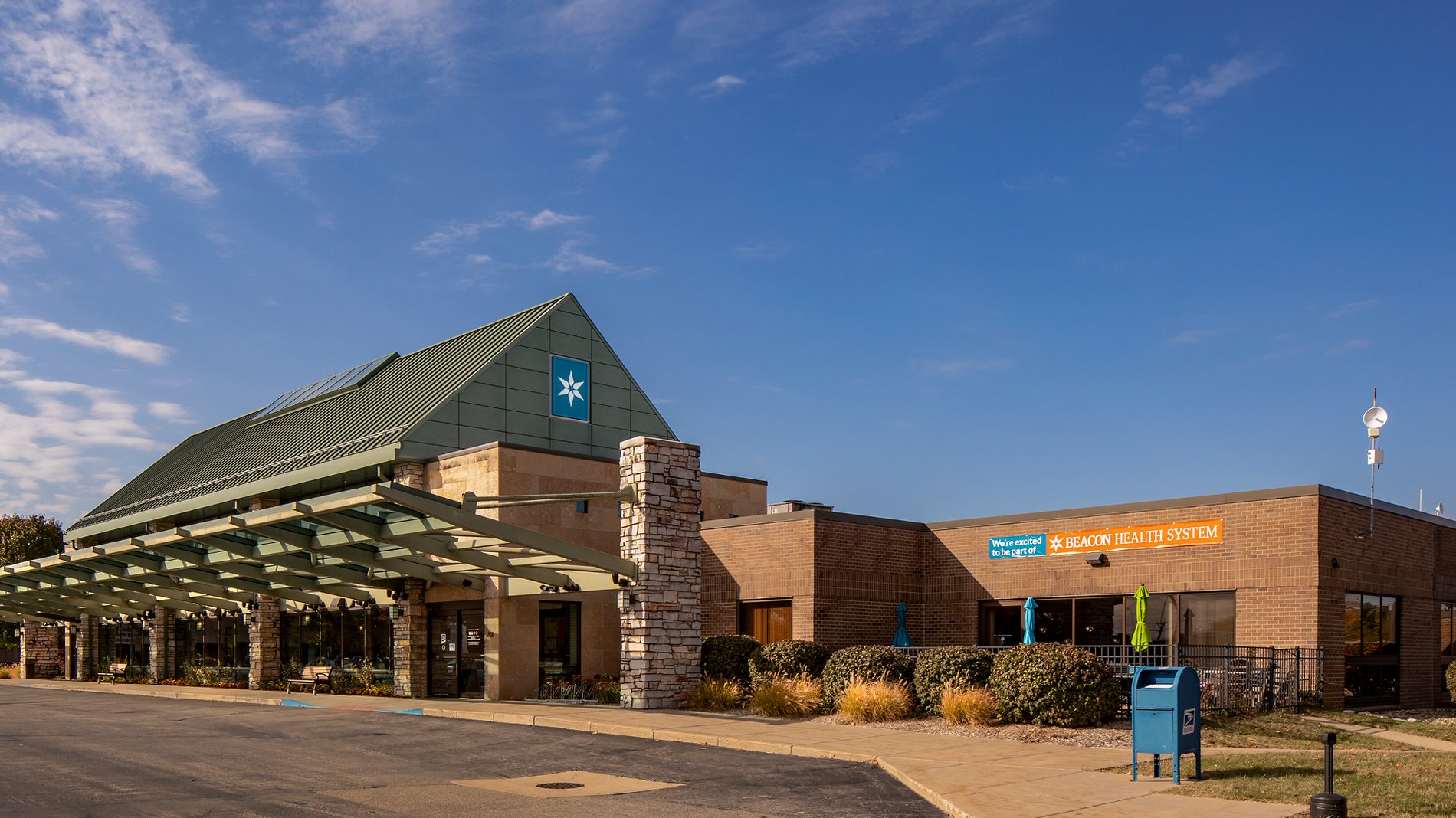 The entrance to Three Rivers Health Hospital has an overhang and a sign that reads, "We're excited to be part of Beacon Health System."