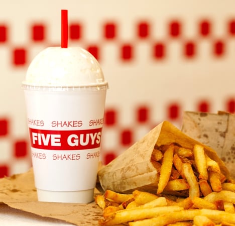 A close-up image of a Five Guys milkshake, with fries.