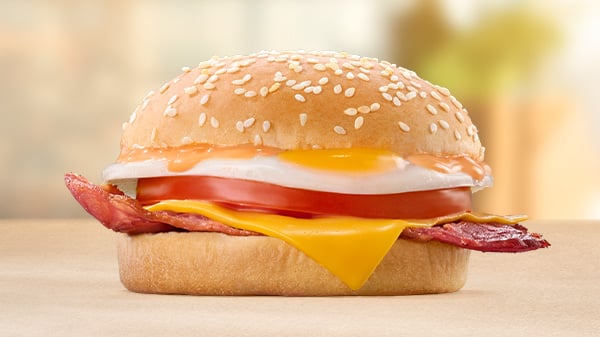 The Macon, Egg, Cheese & Tomato Bun on a brown surface with a blurred background.