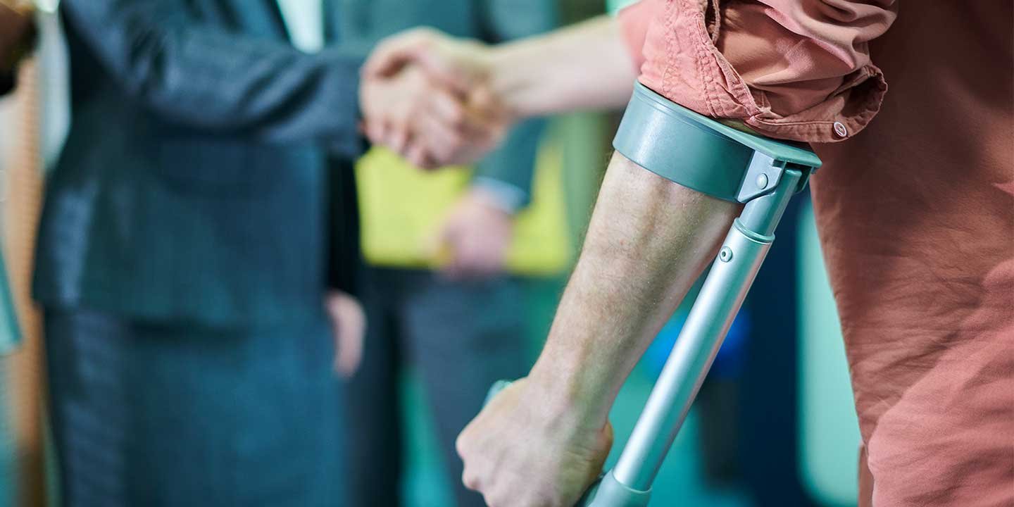 man on crutches shaking hands