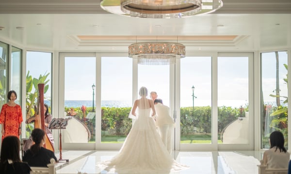 オーシャンビューの会場で結婚式をあげる新郎新婦