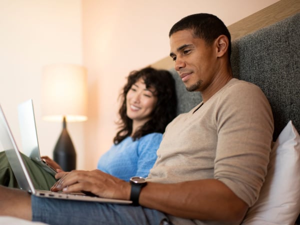 Couple in bed trying to find the best internet provider in Portland, OR