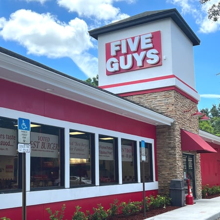 Exterior photograph of the Five Guys restaurant at 898 Saxon Boulevard in Orange City, Florida.