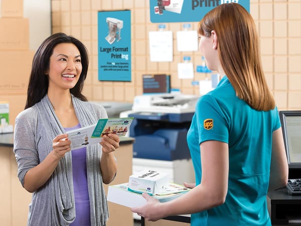 A smiling woman admiring her new printed documents