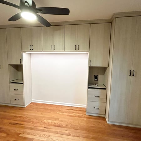 With just enough space for a bed, this sets the mood for a primary or guest bedroom. This system is in Misty Orchard with slab front doors and drawers, along with warm toned bottom cap lighting.