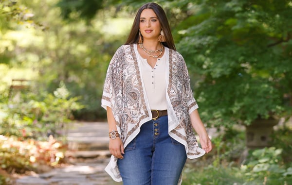 Woman is wearing a white top, patterned kimono and blue jeans.