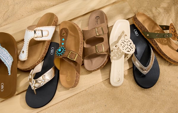 Eight shoes are displayed in a line on top of a wooden platform.