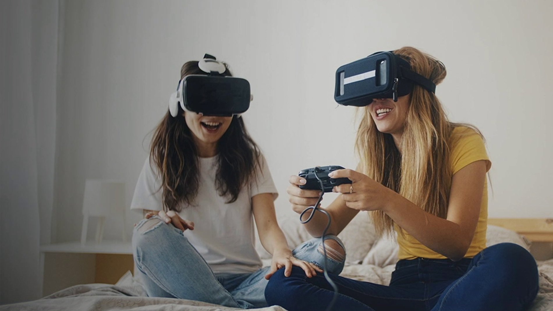 Dos mujeres jugando videojuegos con un auricular VR con Internet superveloz de Optimum
