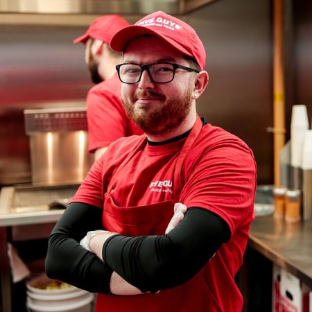 Employé masculin de Five Guys posant pour la caméra