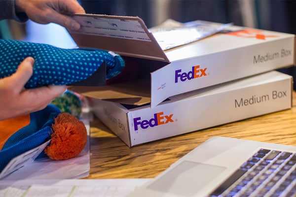FedEx customer placing an item in a one-rate box