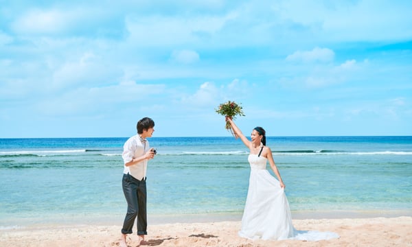 ビーチでウェディングフォトをとる新郎新婦