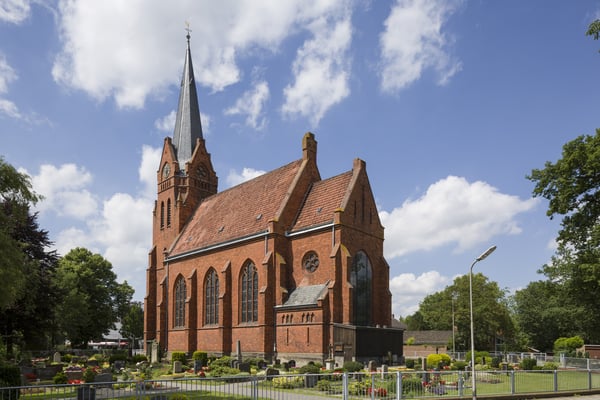 Das Kirchengebäude umgeben von einem Friedhof.