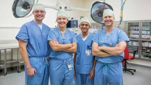 Four Stewart Health Care surgeons pose for a photo inside an operating room.