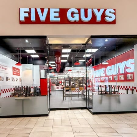 Exterior photograph of the Five Guys restaurant inside Sawgrass Mills mall in Sunrise, Florida.