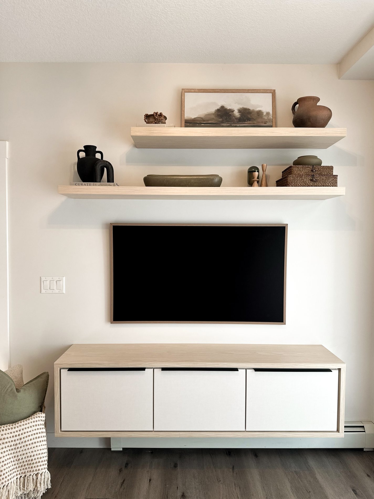 Floating media centre with floating shelves in a natural and white finish.