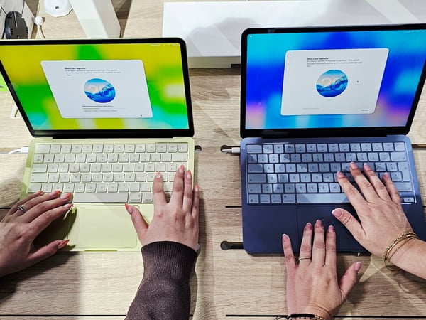 deux ordinateurs en présence de deux mains