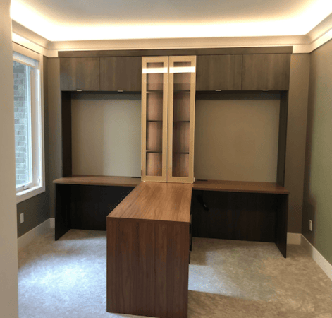 Brown work desk storage with a peninsula, glass doors, and drawers