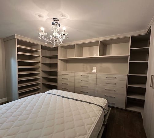 Wall bed with light wood shelving and drawers