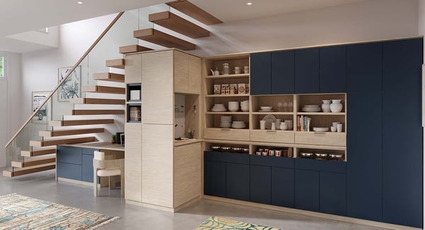 A large custom storage unit with an under stairs workspace, pantry, and family command center in natural woodgrain and matte navy finishes