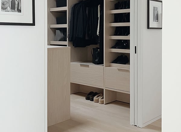 Minimalist custom walk-in closet by California Closets Nashville featuring Natural finish cabinetry, integrated shoe storage, drawers and hanging space.