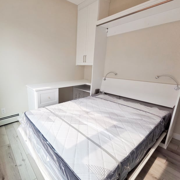 California Closets wall bed and office system. This wall bed is designed with and L shaped desk on the side and upper cabinetry with extra storage.