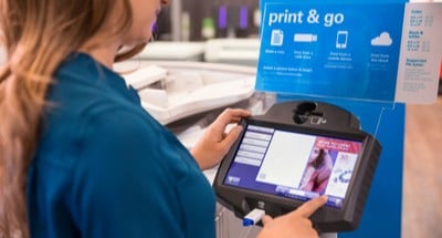 Customer using a self-service printer at FedEx Office to make color copies and quick prints.