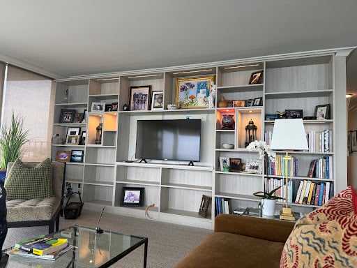 Entertainment center with a mounted television and shelving.