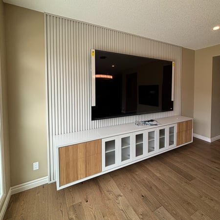 Floating media unit with tambour backing, glass door fronts and contrasting wood doors.