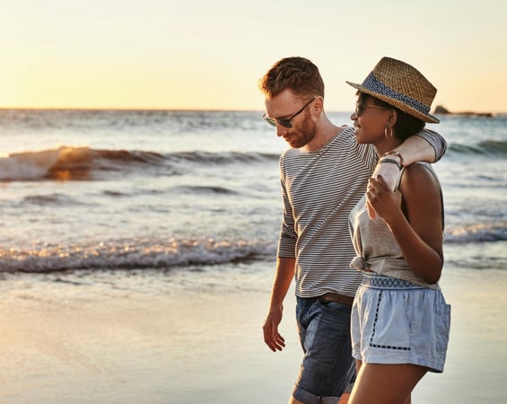 A young couple walking on the beach