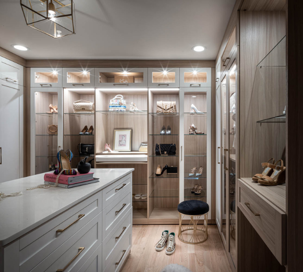 Img 6 California Closets Westchester County New York Two Toned White and Beige Large Walk-in Luxury Closet with Glass Shelving, Glass Doors, Lighting, and a Custom Center Island with Custom Jewelry Drawers
