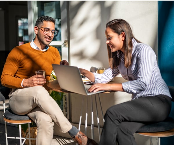 Un hombre y una mujer mirando una laptop