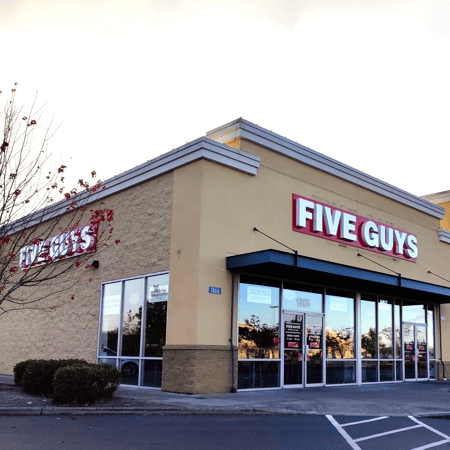 Exterior photo of the front entrance to the Five Guys restaurant at 1870 Marketplace Drive in Burlington, Washington.