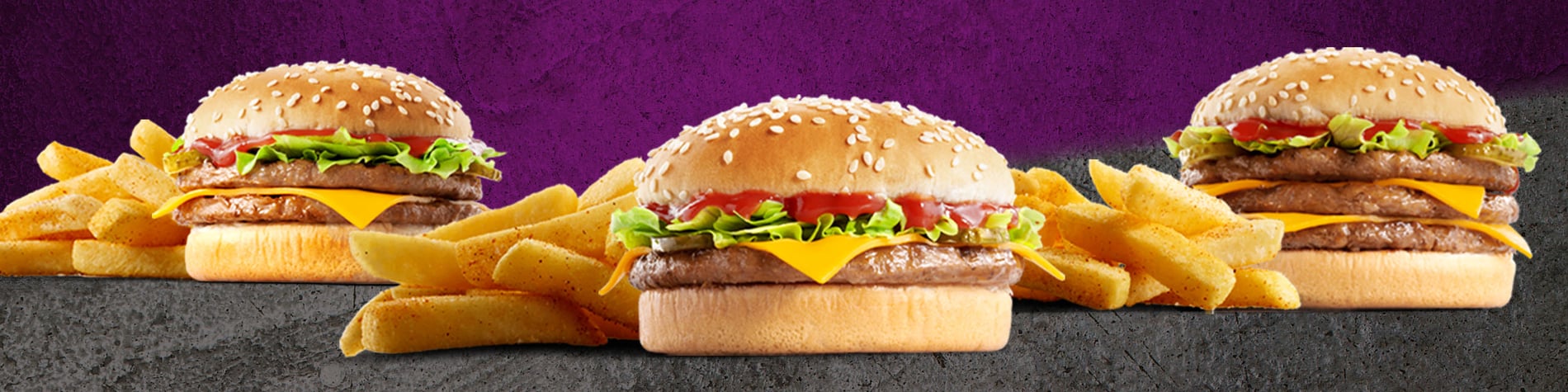 The Single, double and triple Get Real Cheese Burgers meals placed on a grey surface with a purple background.