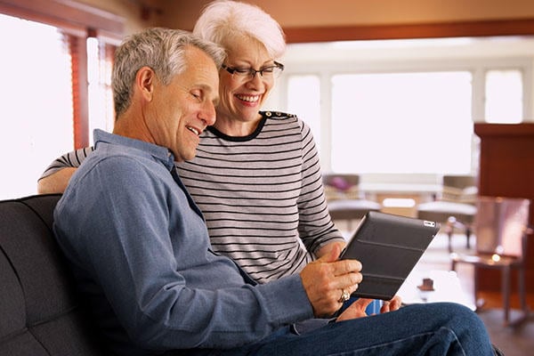 A happy man and woman looking at a tablet