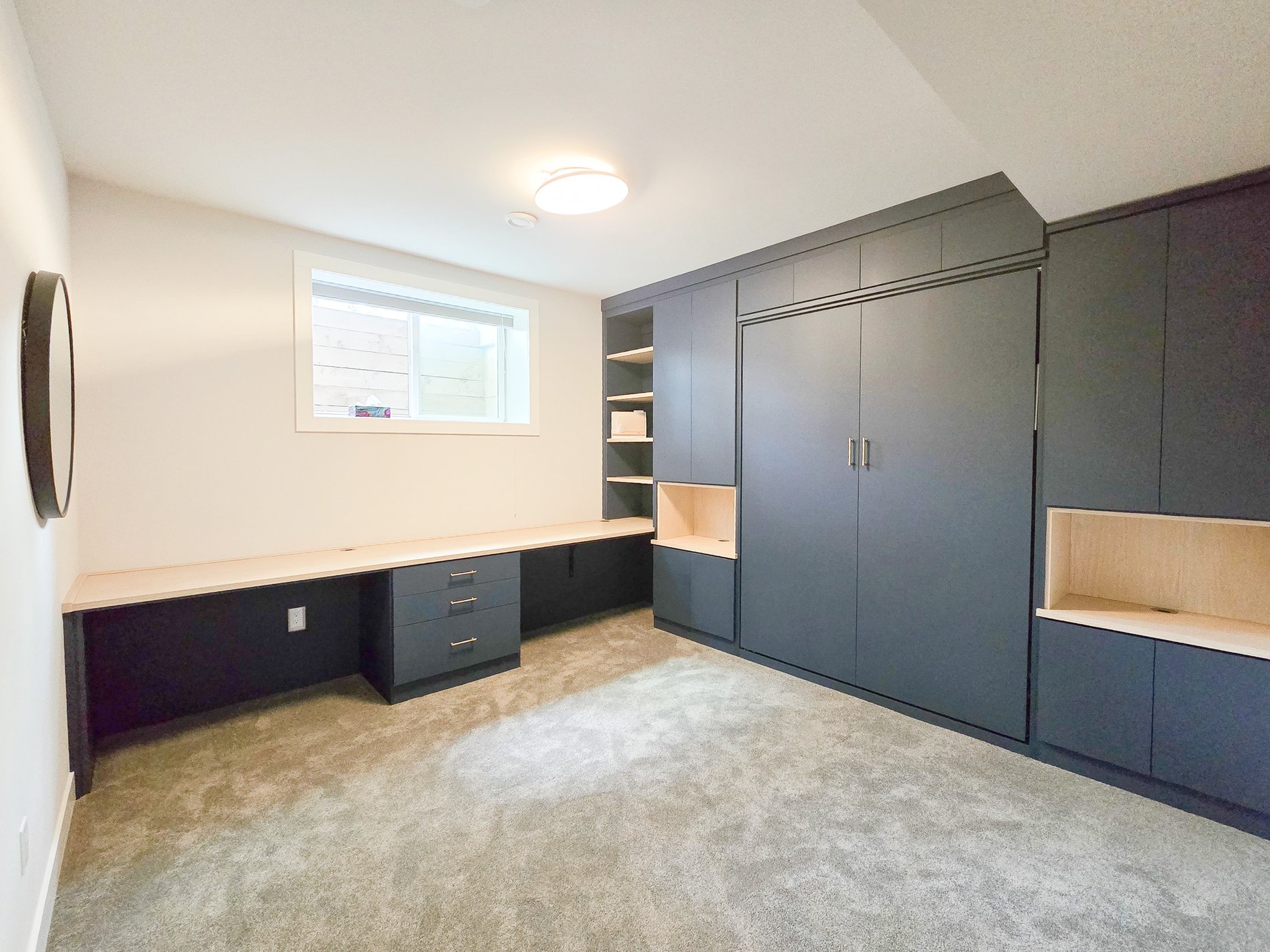 Deep blue wall bed and office system with contrasting countertop and open shelving.