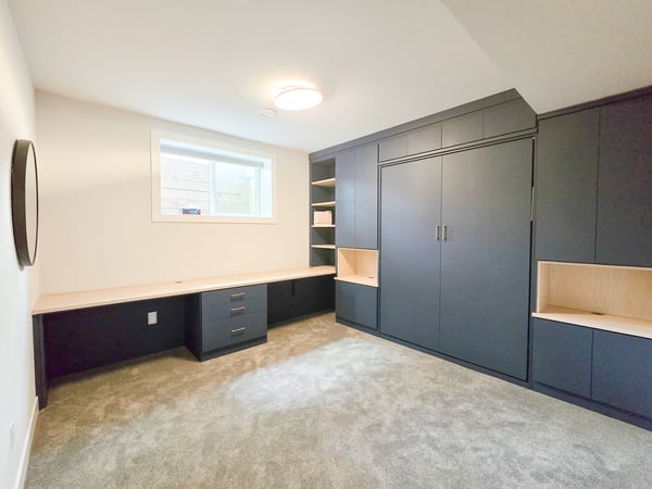 Deep blue wall bed and office system with contrasting countertop and open shelving.
