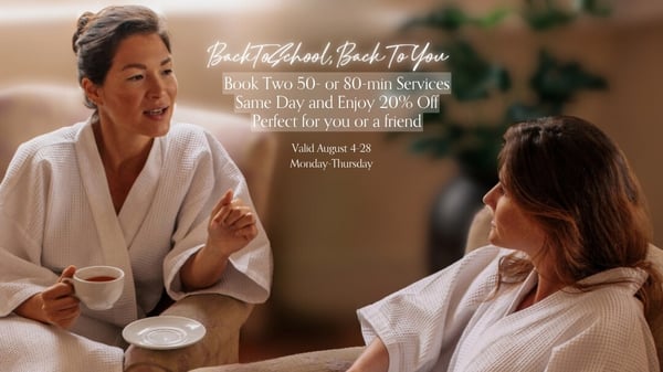 2 women having hot tea in a spa with white robes on