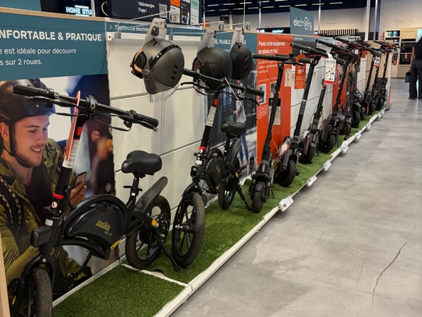 Vue du rayon trottinette électrique avec les produits disposés en magasin.
