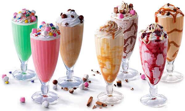 Assorted flavoured milkshakes in tall glasses against a white background.