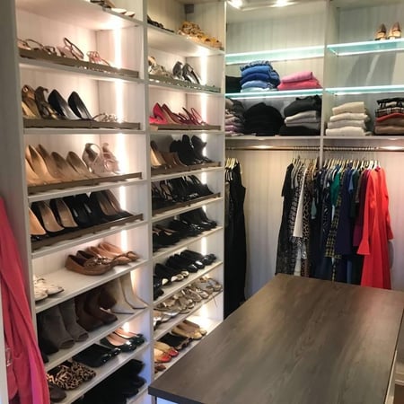 Greensboro - Custom closets - Beautiful walk-in closet with floor-to-ceiling shoe display racks, LED lights, organized clothing, and a center island