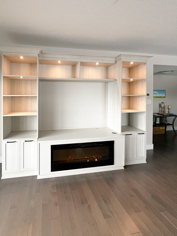 White media centre with an electric fireplace, lighting, and both closed and open shelving.