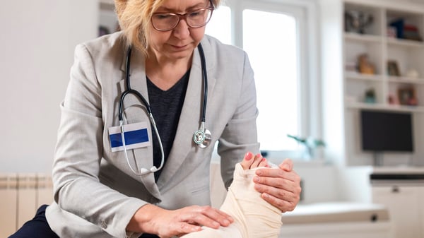 doctor examining patient's bandaged foot