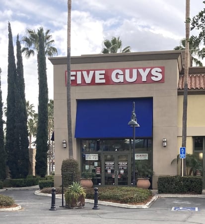 Exterior photograph of the Five Guys restaurant at 10060 Alabama Street in Redlands, California.
