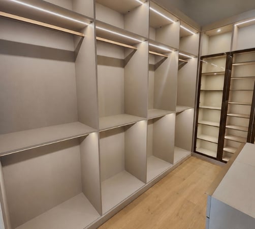 Custom walk-in closet in Boca Raton, FL with glass display doors, double hanging storage, and upper cubby storage by California Closets