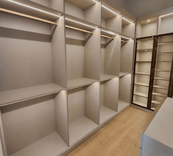 Custom walk-in closet in Boca Raton, FL with glass display doors, double hanging storage, and upper cubby storage by California Closets