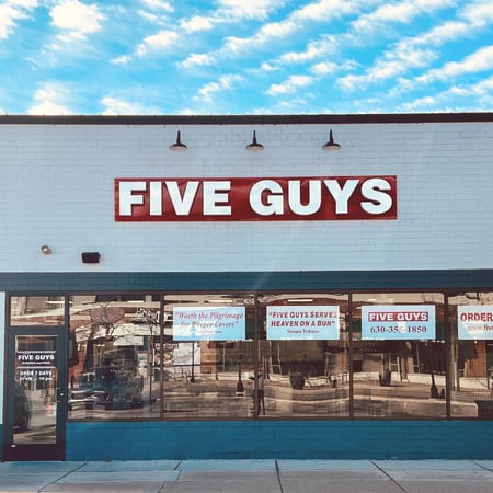 Exterior photograph of the Five Guys restaurant at 22 E Chicago Avenue in Naperville, Illinois.